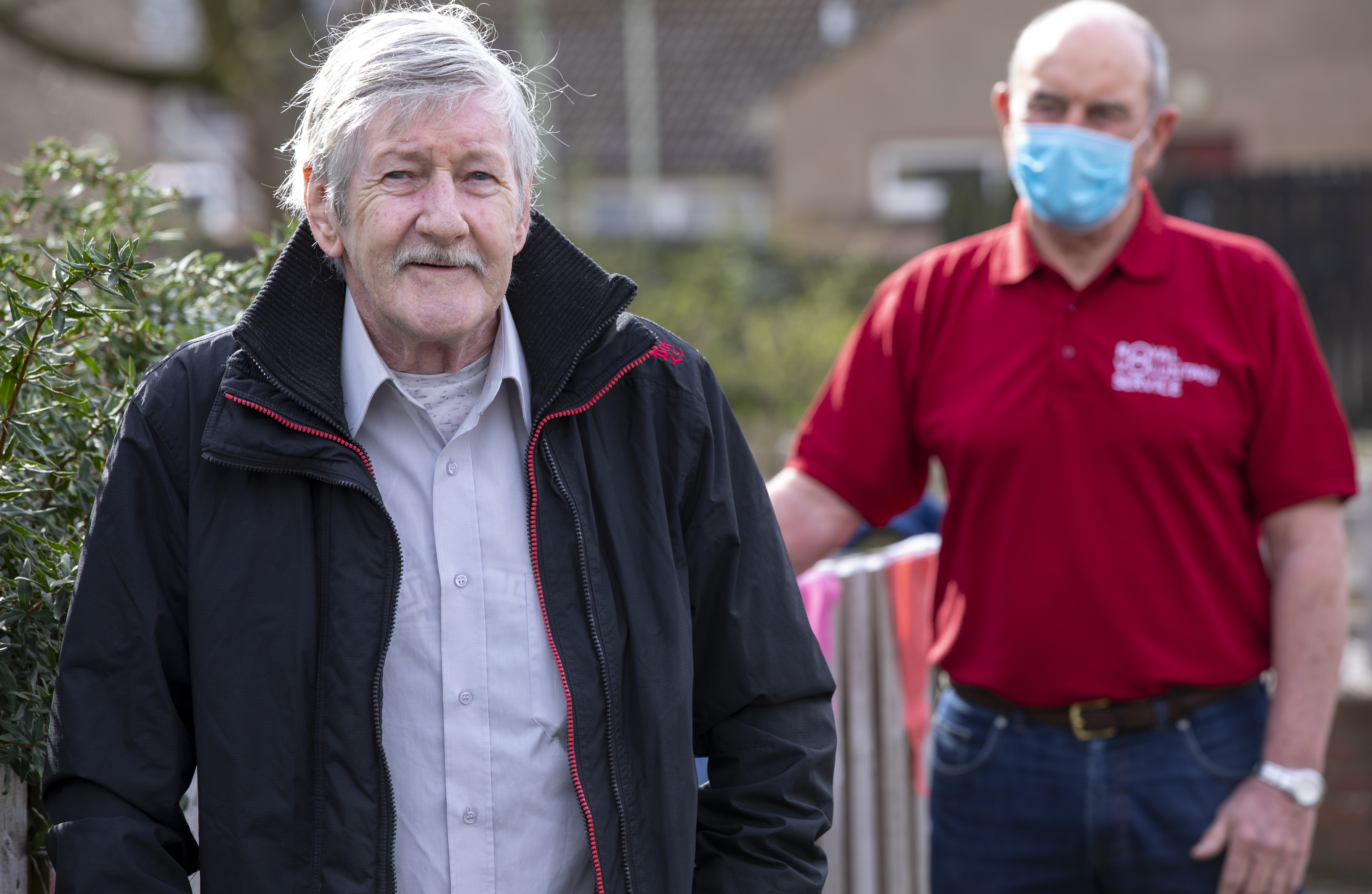 Older man standing with support worker.